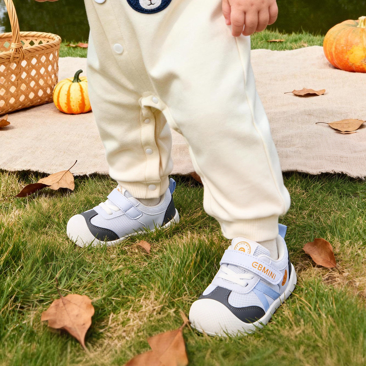 Child wearing blue EBMINI AERO baby sneakers outdoors