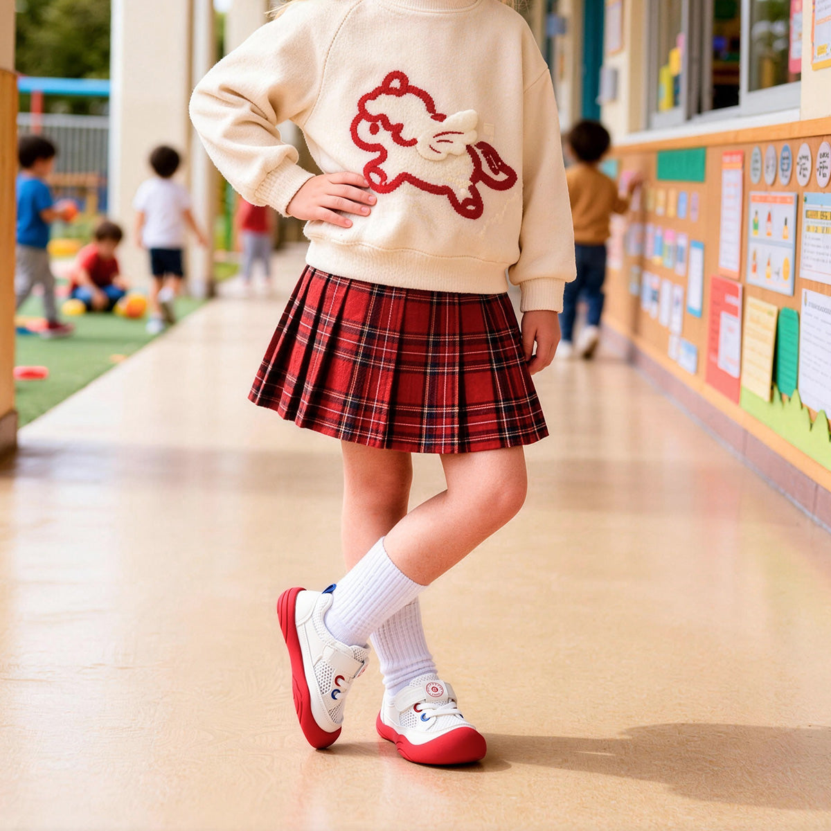 Child wearing white EBMINI AERO sneakers with red outsole in an indoor play setting