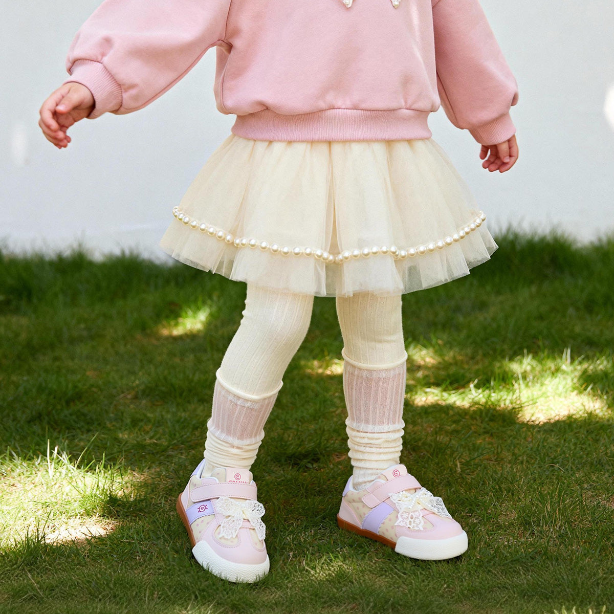 Child wearing Pink EBMINI DOTE toddler sneakers outdoors