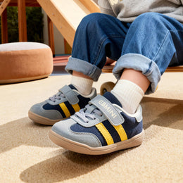 Child wearing blue EBMINI GROOVE double-stripe toddler sneakers
