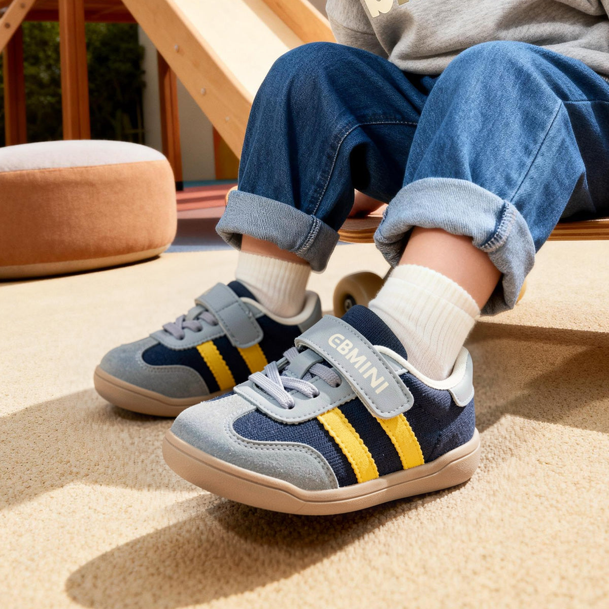 Child wearing blue EBMINI GROOVE double-stripe toddler sneakers