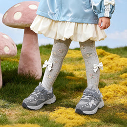 Girl wearing gray EBMINI PEARL glitter bow sneakers outdoors